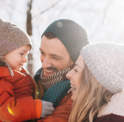 image de deux parents tenant leur enfant dans les bras