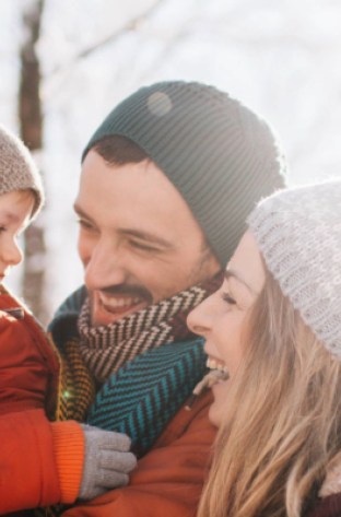 image de deux parents tenant leur enfant dans les bras